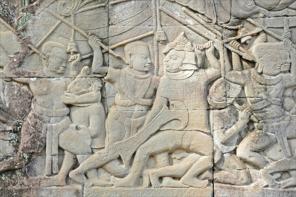 Bas-relief en couleur du temple de Bayon représentant une scène de combat entre guerriers khmers, sculptée dans la pierre à Angkor, Cambodge.